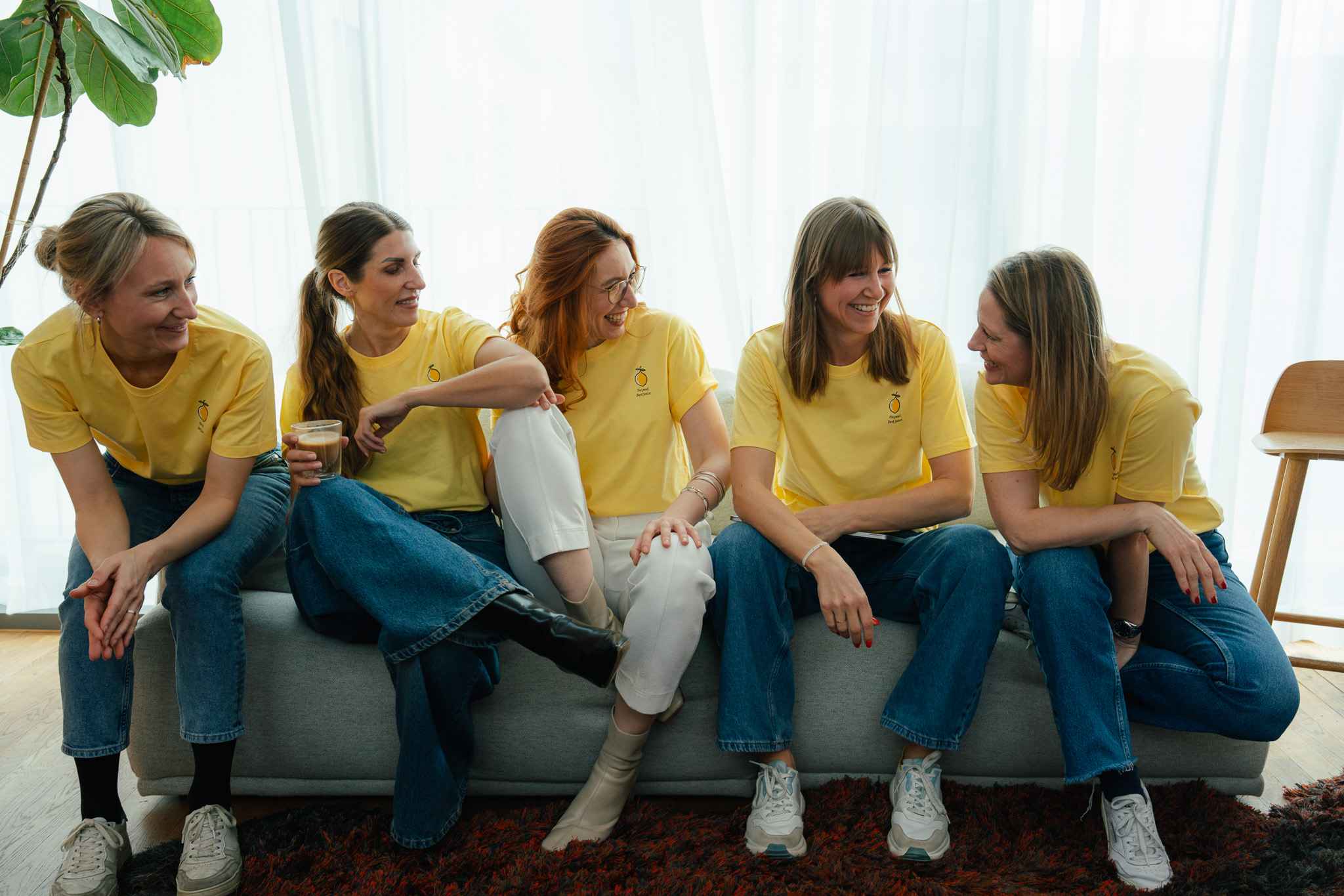 Das lemonshots Team in gelben T-Shirts auf einem Sofa